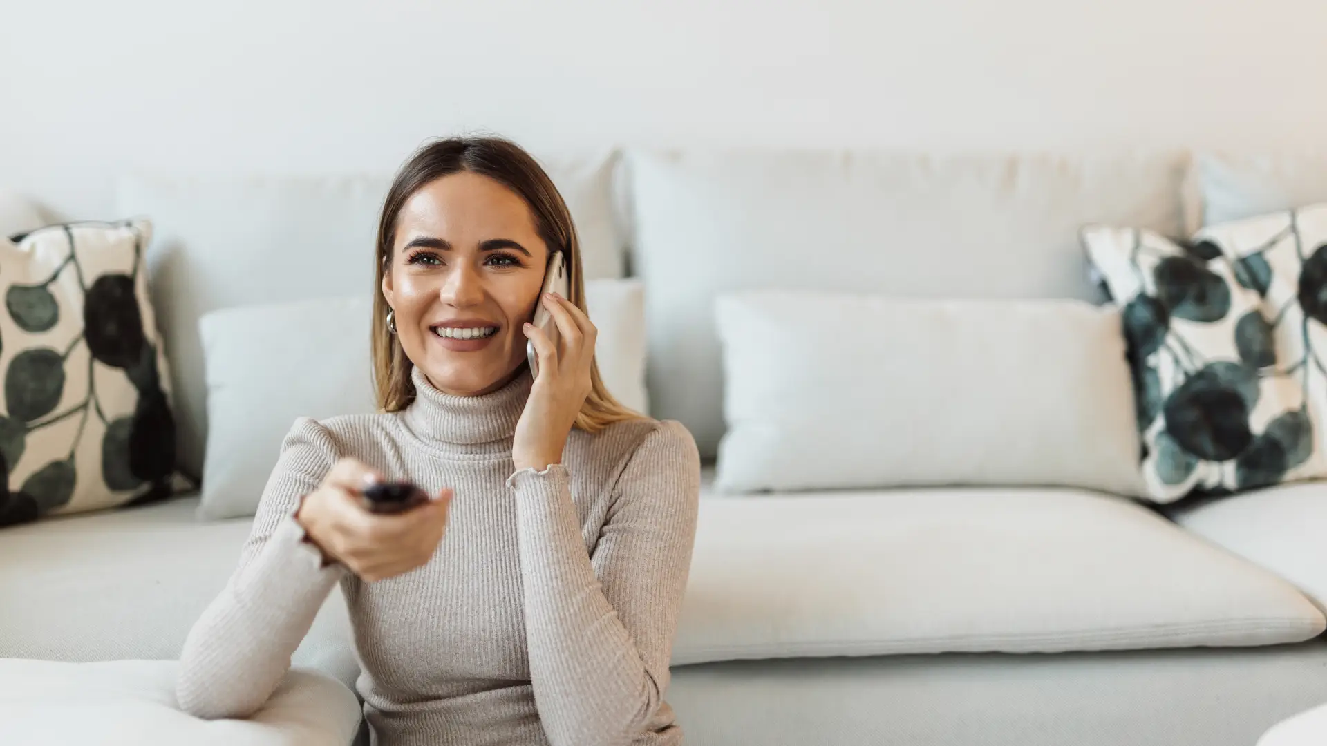 Una mujer llamando por telefono desde el sofá a la atención al cliente de Diseny Plus Una mujer llamando por telefono desde el sofá a la atención al cliente de Diseny Plus