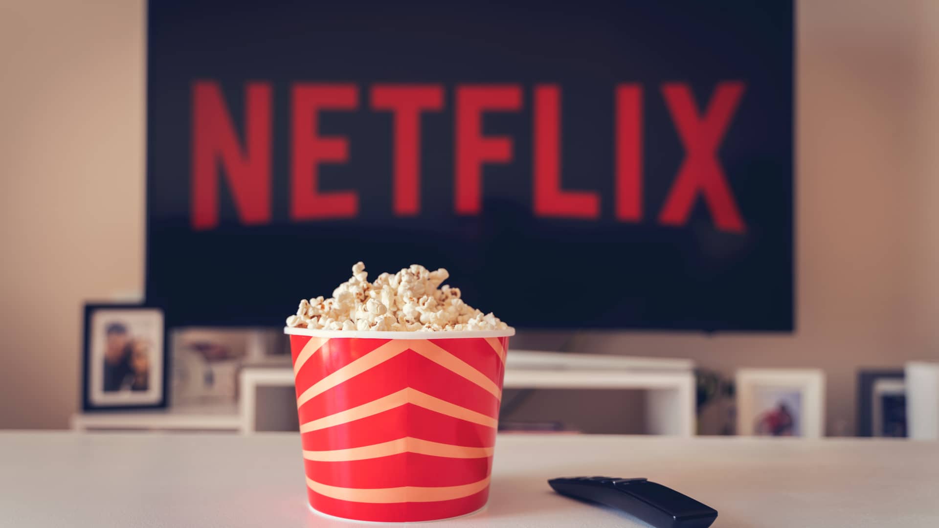 pantalla de television con el logo de netflix con un bote de palomitas delante que significa que netflix no es gratis pantalla de television con el logo de netflix con un bote de palomitas delante que significa que netflix no es gratis