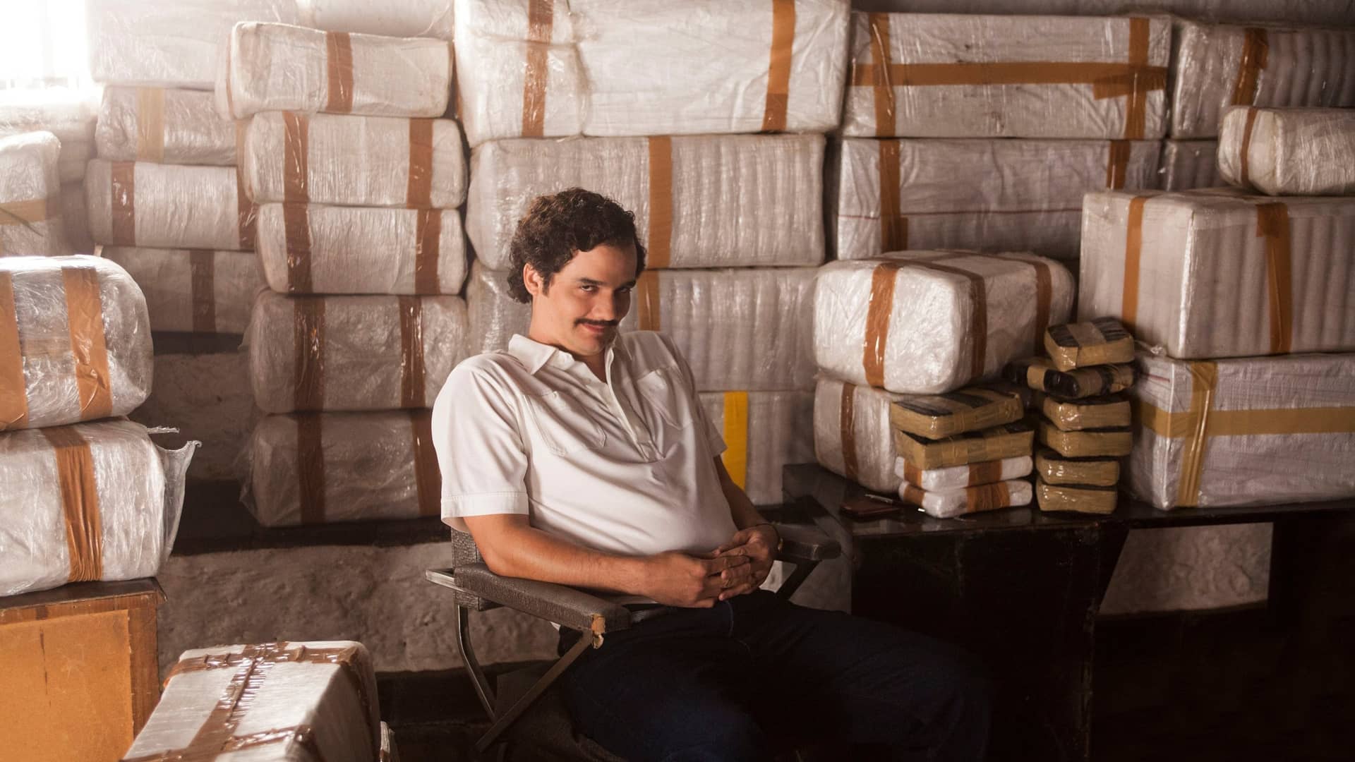 protagonista de la serie de narcotrafico de netflix titulada narcos delante de unos fardos de droga protagonista de la serie de narcotrafico de netflix titulada narcos delante de unos fardos de droga