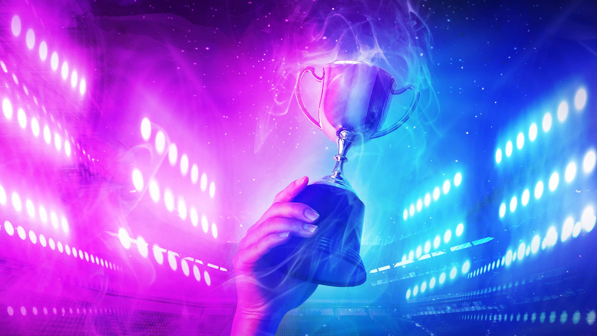 Mano levantando un trofeo con luces moradas y azules de fondo simboliza al número uno actual en el ranking de top streamers de twitch Mano levantando un trofeo con luces moradas y azules de fondo simboliza al número uno actual en el ranking de top streamers de twitch